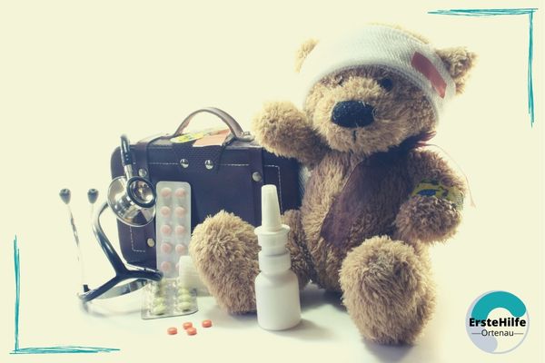 Ein Teddy mit Verband, Arztkoffer und Medikamenten