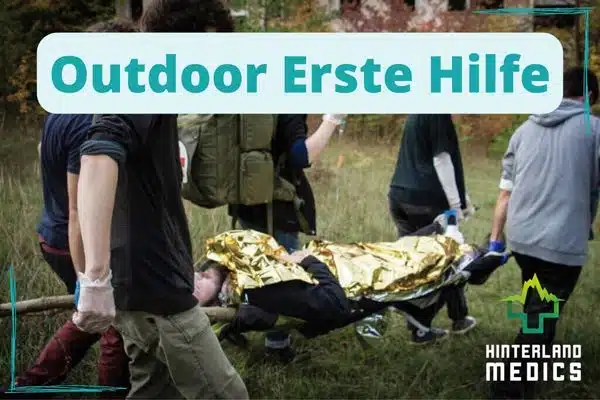 vier Personen Tragen einen verletzten auf einer Trage bei einem Outdoor Erste Hilfe Kurs